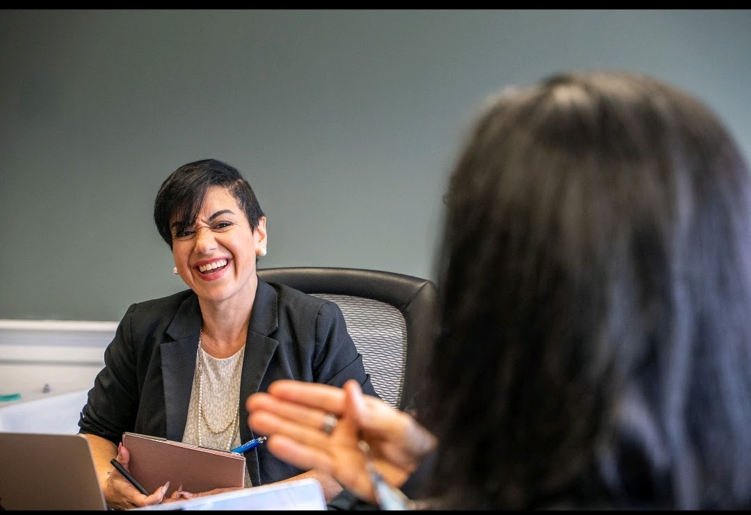 Brenda Ortiz McGrath in conversation at a leadership table, guiding collaborative work.